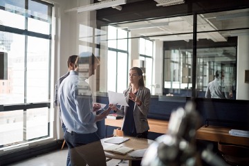 businesswoman-talking-to-colleague-in-office 360 x 240